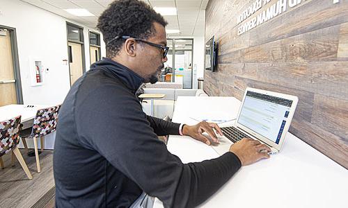 一个学生在笔记本电脑前工作