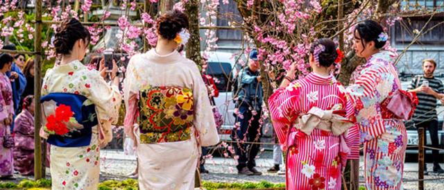 two women in kimonos standing next to each other.