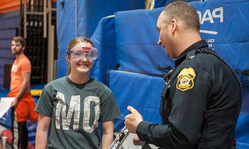 戴着醉醺醺的护目镜的学生和警察谈话